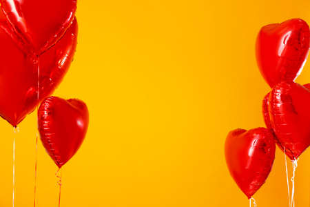 Heart shaped air balloons on color backgroundの写真素材