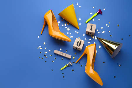 High-heels with party decor and calendar with date of April Fools Day on color background