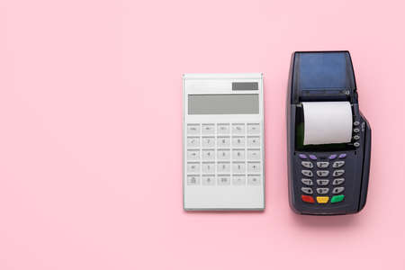Calculator with payment terminal on color backgroundの写真素材