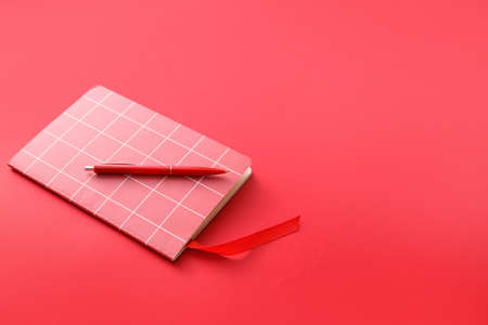 Notebook with bookmark and pen on color backgroundの写真素材