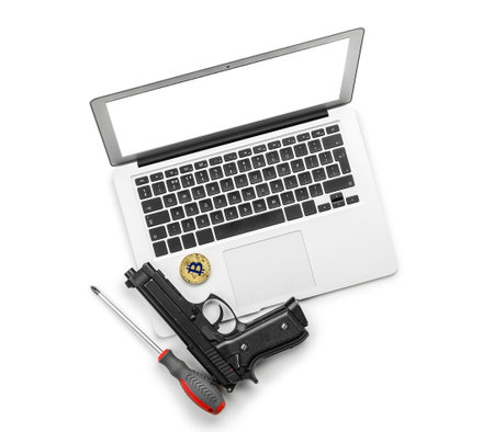 Laptop, bitcoins, gun and screwdriver on white background. Hacking concept