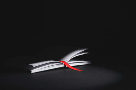 Open book with bookmark on dark backgroundの写真素材