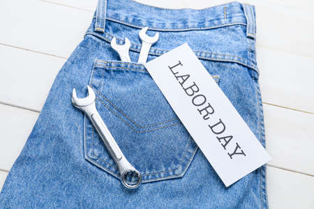 Jeans and tools on white wooden background. Labor Day celebrationの写真素材