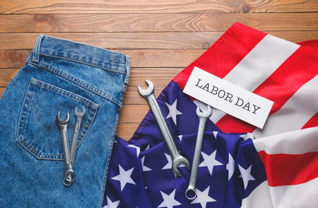 Set of tools, jeans and USA flag on wooden background. Labor Day celebration