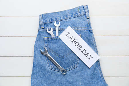 Jeans and tools on white wooden background. Labor Day celebrationの写真素材