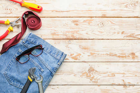 Set of tools and jeans on light wooden background. Labor Day celebrationの写真素材