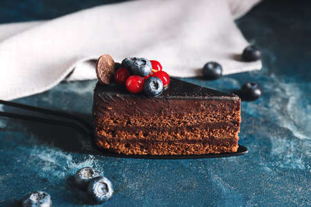 Shovel with tasty chocolate cake on color backgroundの写真素材