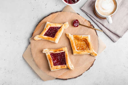 Board with Danish pastry on light background
