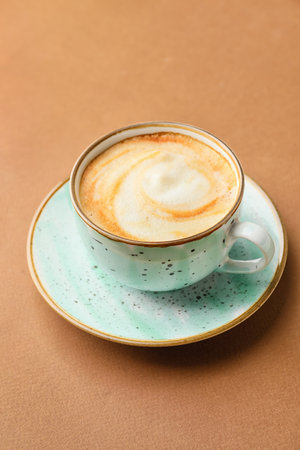 Cup of hot cappuccino coffee on color backgroundの写真素材