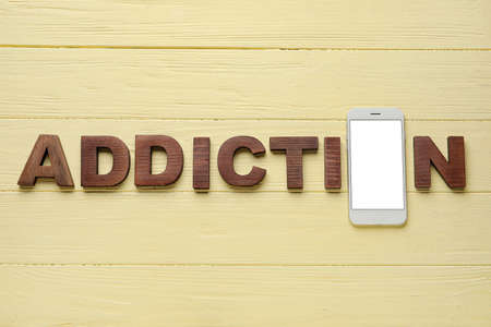 Mobile phone and word ADDICTION on wooden backgroundの写真素材