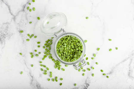 Jar with green coffee beans on light backgroundの写真素材
