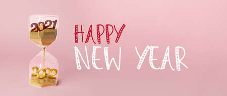 Hourglass with sand and figures 2021 and 2022 on color background. New Year celebrationの写真素材