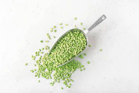 Scoop with green coffee beans on light backgroundの写真素材