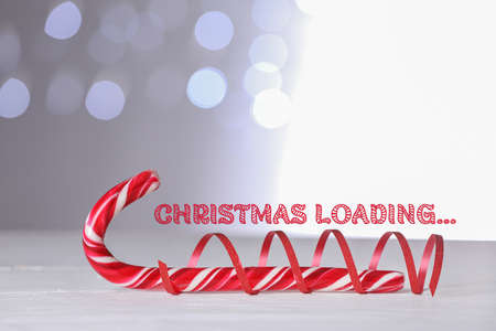 Christmas candy cane on table against blurred lights