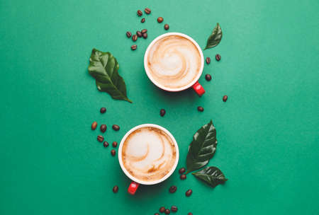 Cups of hot cappuccino on color backgroundの写真素材