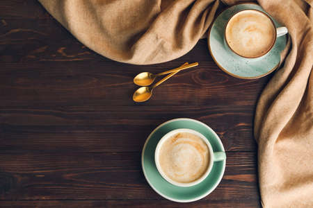 Cups of hot cappuccino on wooden backgroundの写真素材