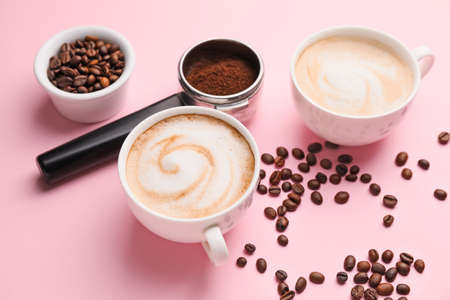 Cups of hot cappuccino on color backgroundの写真素材