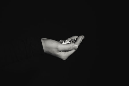 Hand with pills on dark background. Concept of addictionの写真素材