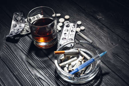 Alcohol, drugs and cigarettes on table. Concept of addictionの写真素材