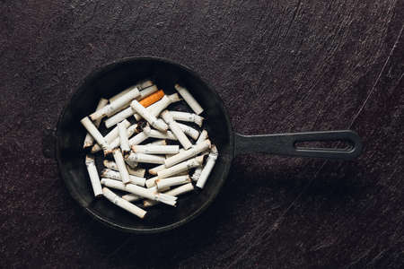 Frying pan with many cigarettes on dark background. Concept of addictionの写真素材