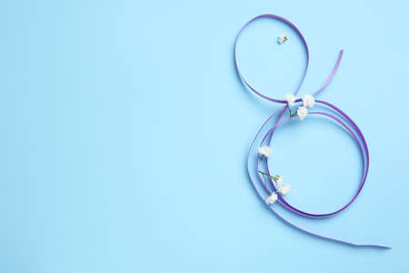 Figure 8 made of violet ribbon on color background. International Women's Day celebrationの写真素材