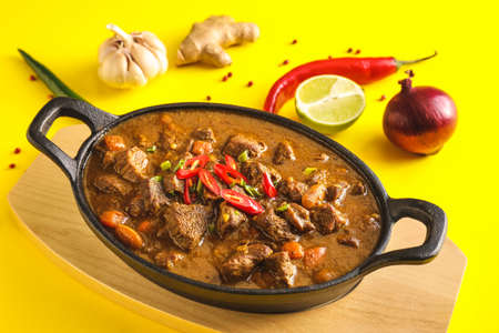 Dish with tasty beef curry on color background