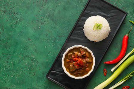 Bowl with tasty beef curry and rice on color backgroundの写真素材