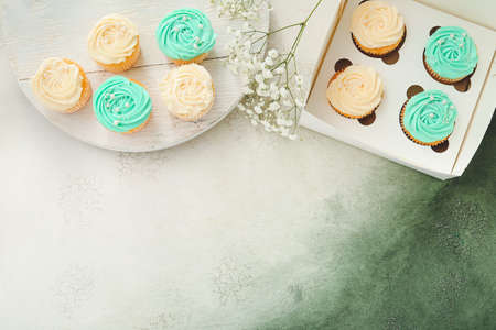 Composition with tasty cupcakes and flowers on color backgroundの写真素材