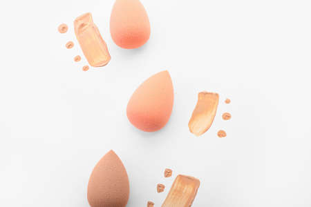 Stylish makeup sponges and foundation samples on white backgroundの写真素材
