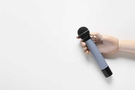 Wooden hand with modern microphone on white backgroundの写真素材