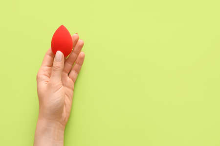 Hand with makeup sponge on color backgroundの写真素材