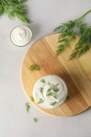 Bowls of tasty sour cream and herbs on gray backgroundの写真素材