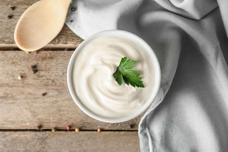 Bowl of tasty sour cream on wooden tableの写真素材