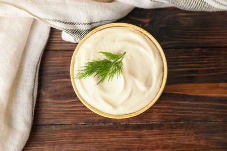 Bowl of tasty sour cream on dark wooden tableの写真素材