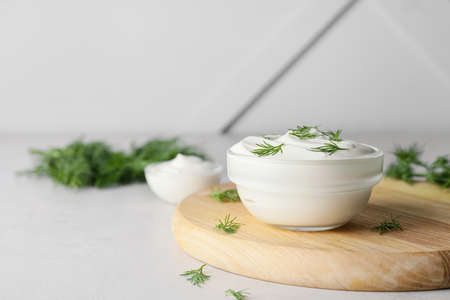 Bowl of tasty sour cream and herbs on gray backgroundの写真素材