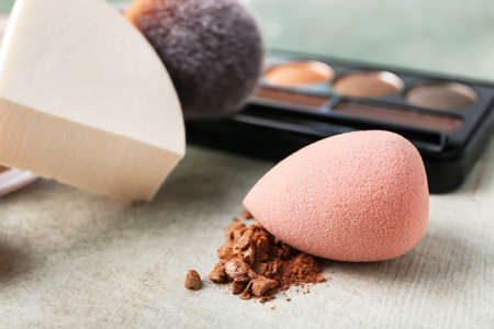 Makeup sponges and cosmetics on tableの写真素材