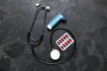 Modern inhaler, pills and stethoscope on dark backgroundの写真素材