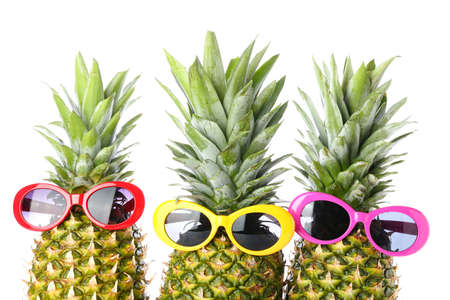 Funny pineapples in sunglasses on white backgroundの写真素材