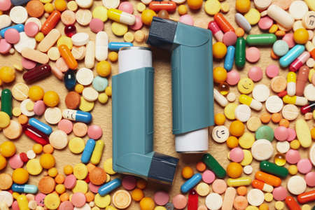 Modern inhalers and pills on color background, closeupの写真素材