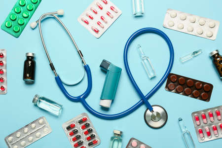 Inhaler, stethoscope and medicines on color backgroundの写真素材