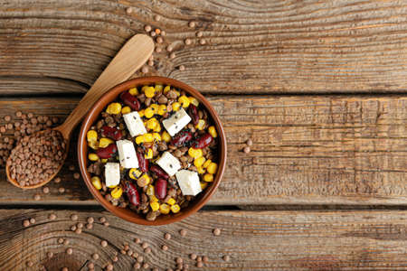 Bowl of tasty cooked lentils, beans and cheese on tableの写真素材