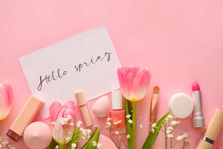 Cosmetics and spring flowers on color backgroundの写真素材