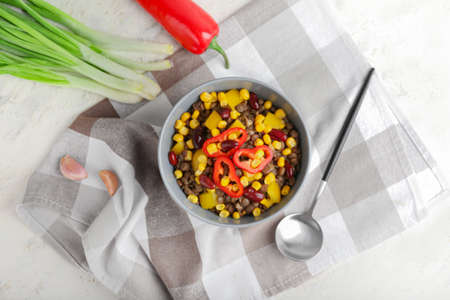 Bowl of tasty cooked lentils, beans and vegetables on tableの写真素材