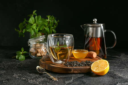 Glass of hot tea with lemon and honey on dark backgroundの写真素材