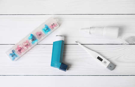 Composition with inhaler on white wooden background