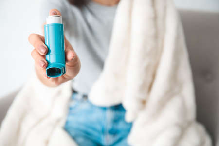 Woman with inhaler at homeの写真素材