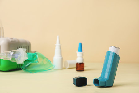 Modern inhaler on color wooden background