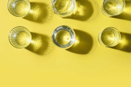 Glasses of water on color background