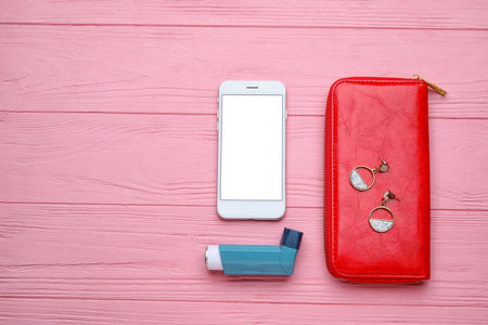 Composition with inhaler and mobile phone on color wooden backgroundの写真素材