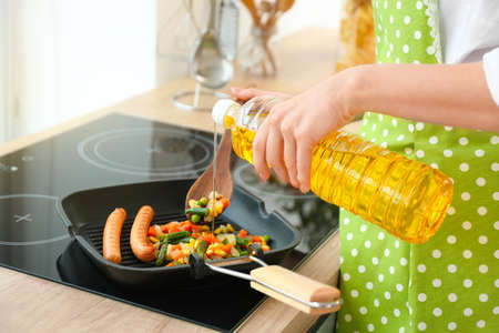 Woman cooking tasty breakfast in kitchenの写真素材